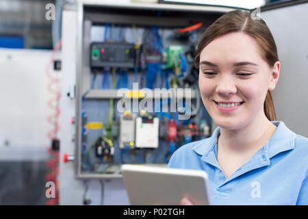 Ingegnere femmina in fabbrica con tavoletta digitale Foto Stock