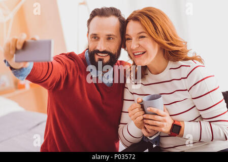Dire il formaggio. Donna felice mantenendo il sorriso sul suo viso mentre si posa su telecamera Foto Stock