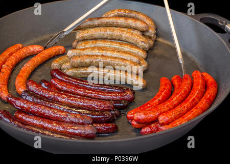 Scenario di barbecue con un sacco di vari salsicce arrostite in una padella Foto Stock