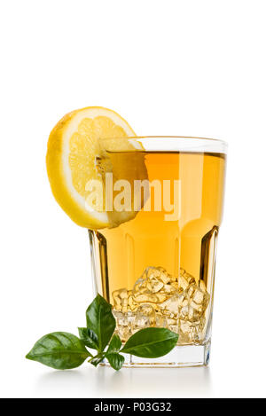 Bicchiere pieno di ghiaccio tè con fette di limone e foglie di tè su sfondo bianco Foto Stock