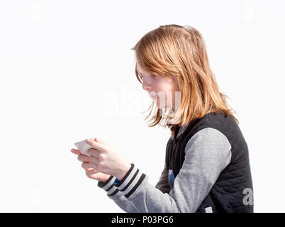 Ragazzo con capelli lunghi giochi sul telefono cellulare. Foto Stock