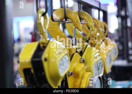 Industriali di catene in acciaio in giallo di paranchi di sollevamento ; messa a fuoco selettiva Foto Stock
