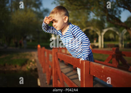 Little Boy guarda a distanza Foto Stock