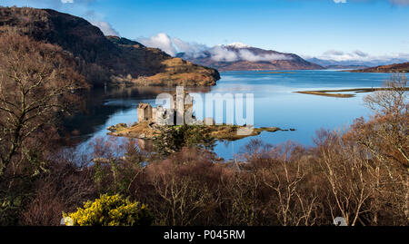 La vista lungo il Loch Alsh alle montagne di Skye in distanza con il vecchio castello del XIII secolo di Eilean Donan seduto su una piccola isola Foto Stock