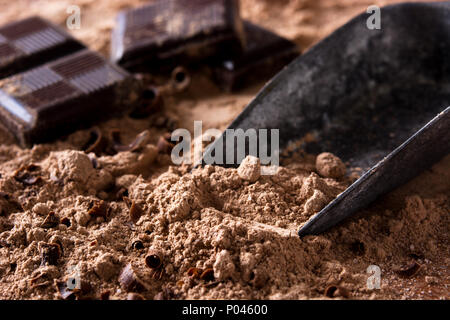 Pezzetti di cioccolato sul cioccolato in polvere. Close up Foto Stock