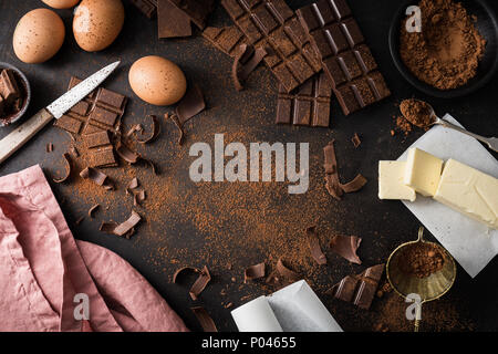 Da ingredienti di cui sopra per la cottura di pasta cioccolato brownies o torta sul tavolo scuro. Vista da sopra con lo spazio di copia Foto Stock