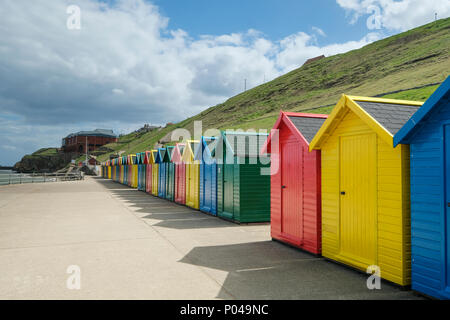 Fila di cabine sulla spiaggia, a Whitby in Yorkshire Foto Stock