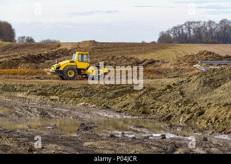 Giallo compattatore a rulli a argilloso sito in costruzione Foto Stock