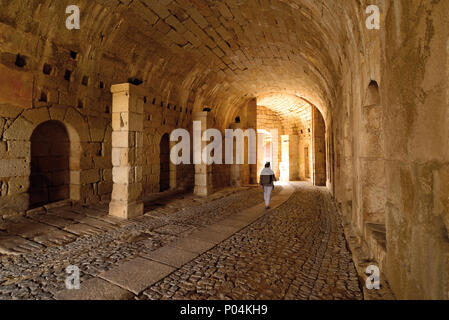 Donna che cammina in un tunnel fortificato verso l'uscita Foto Stock