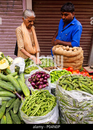 Il vecchio donna indiana acquistare verdure a Sangatrashan Bazar, Paharganj, New Delhi, India Foto Stock