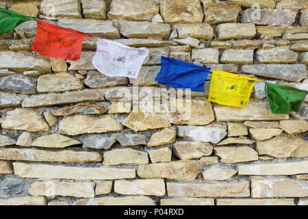 La preghiera buddista bandiere sul muro di pietra Foto Stock