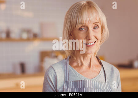 Ritratto di affascinante femmina senior barista sorridente Foto Stock