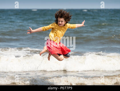 Edinburgh, Regno Unito, 9 giugno 2018. Sabato 9 Giugno 2018: Edimburgo, Scozia - Previsioni. Josie O'Brien 10, da Edimburgo ha alcuni divertenti spruzzi delle onde sulla spiaggia di Portobello Edinburgh. Foto Stock