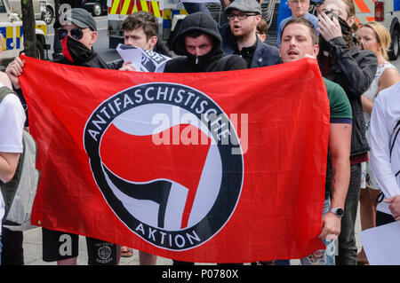 Belfast, Irlanda del Nord. 09/06/2018 - Irlanda del Nord Antifa membri, molti con il volto coperto, protesta contro un rally a sostegno del British prima di Tommy Robinson, imprigionato nel maggio 2018 per disprezzo della corte. Foto Stock