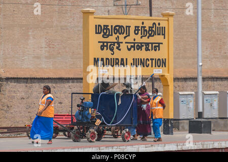 Madurai, India - 10 Marzo 2018: i lavoratori del settore ferroviario negoziando una piattaforma su Madurai stazione di giunzione con la loro attrezzatura Foto Stock