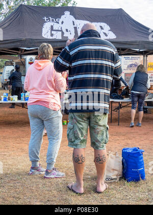 Gibb Challenge 2018 un paio in piedi presso il campeggio, il maschio con tatuaggi di un gigante di mountain bike e biciclette speciali vitelli Kimberley WA Australia. Foto Stock