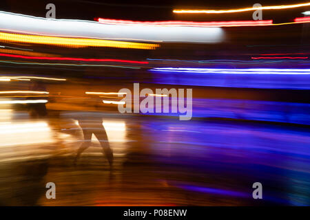 Abstract luci di coda lungo la strada di notte con la gente Foto Stock