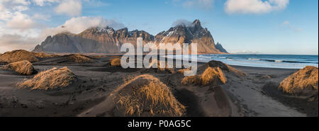 Lunga spiaggia di lava, spiaggia di sabbia nera, dune ricoperte di erba secca, montagne Klifatindur, Eystrahorn e Kambhorn Foto Stock