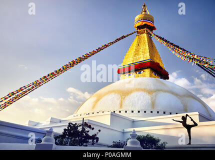 Silhouette di uomo fare yoga natarajasana a Bodnath grande stupa buddisti con la preghiera le bandiere di Kathmandu Foto Stock