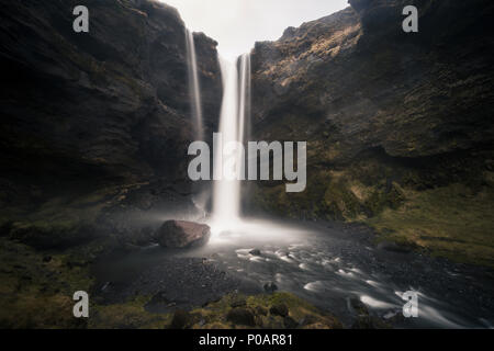 Kvernufoss cascata in una gola, drammatica atmosfera scura, tempo di esposizione, vicino Skógafoss, Southurland, Islanda Foto Stock