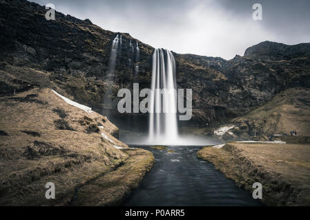 Atmosfera scura, cascata Seljalandsfoss, fiume Seljalandsa, Regione meridionale Islanda Foto Stock