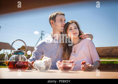 I futuri genitori mangiare fragole all'aperto Foto Stock