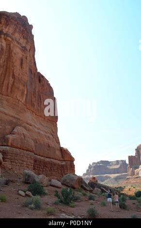 Due ragazze a piedi e tenendo le mani vicino al Park Ave sentiero escursionistico nel Parco Nazionale di Arches, al di fuori del paese di Moab, Utha Foto Stock