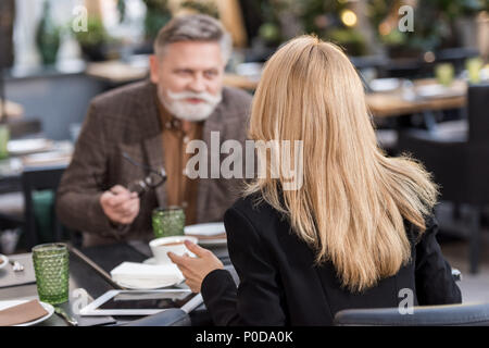 Messa a fuoco selettiva di imprenditore e imprenditrice avente riuniti in cafe Foto Stock
