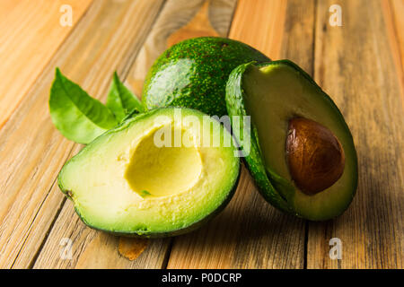 Fresco frutto di avocado su una tavola di legno Foto Stock