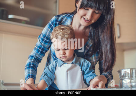 Madre e figlio per la cottura in cucina e guardando verso il basso Foto Stock