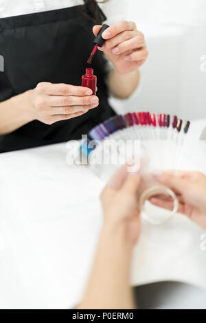 Ritagliato colpo di donna scelta di smalto per unghie color Foto Stock