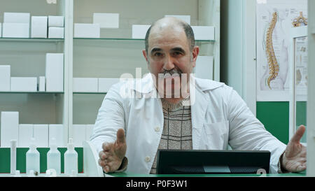 Il farmacista senior di parlare a una telecamera presentazione consigli di medicina di cure mediche in farmacia shop Foto Stock
