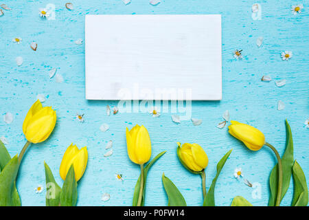 Piano portapaziente ciano scena con tulipani gialli e bianchi telaio in legno Foto Stock