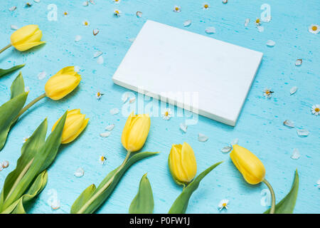 Piano portapaziente ciano scena con tulipani gialli e bianchi telaio in legno Foto Stock