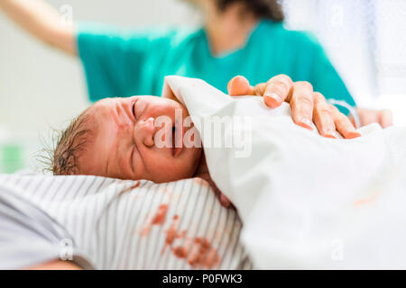 Neonato ragazzo con il lavoratore in ospedale in background Foto Stock