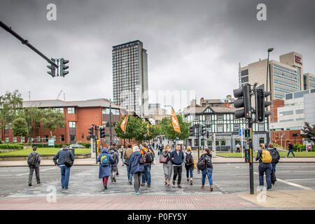 Pendolari sul modo di lavorare nei pressi della stazione ferroviaria di Sheffield Regno unito a un attraversamento pedonale Foto Stock