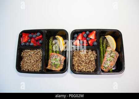 Pianificate i pasti in contenitori - salmone con asparagi, quinoa e frutta fresca. Foto Stock