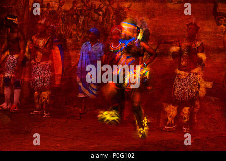 Brillantemente colorati ballerini africani Abstract in movimento e la gente in costume nativo contro una texture di sfondo rosso Foto Stock