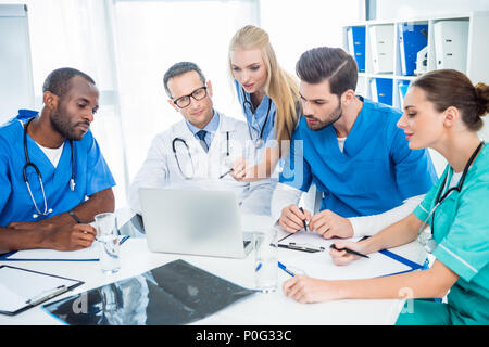 Multietnica team di medici e di brainstorming con laptop Foto Stock