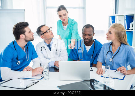 Multietnica concentrato team di medici e di brainstorming con laptop Foto Stock