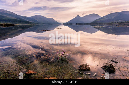 Pacifico Loch Leven riflessioni la mattina presto su una chiara giornata di primavera , le Highlands scozzesi, Scotland, Regno Unito Foto Stock