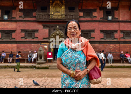 Una donna nepalese anziana di fronte ad un tempio a Kathmandu, Nepal Foto Stock