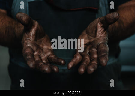 Primo piano delle mani maschio coperti di olio di macchina. Foto Stock