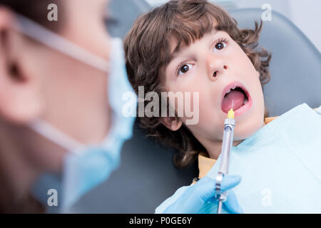 Vista parziale di dentista dando iniezione sull'anestesia al paziente in studio dentistico Foto Stock