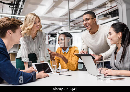 Felice giovane manager che lavorano insieme in sala conferenza in ufficio moderno Foto Stock