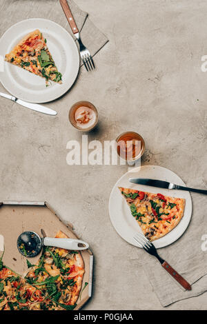 La cena modello con fette di pizza su piatti e bicchieri su sfondo chiaro Foto Stock