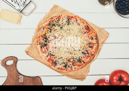 Pizza con gli ingredienti della cucina bianca su sfondo di legno Foto Stock