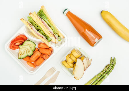 Vista dall'alto di panini, frutta e verdura in scatole di pranzo isolato su bianco Foto Stock