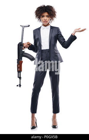 Confuso americano africano femmina agente segreto con un fucile, isolato su bianco Foto Stock