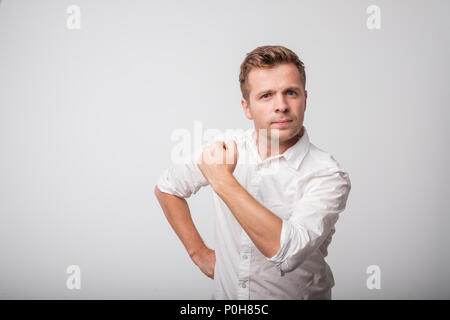 Sicuro di sé uomo di mezza età in camicia bianca con un pugno chiuso Foto Stock